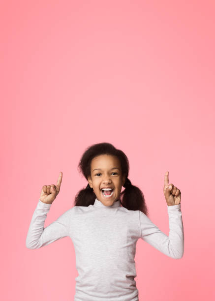 istock Emotional girl pointing fingers up on copy space 1137013300