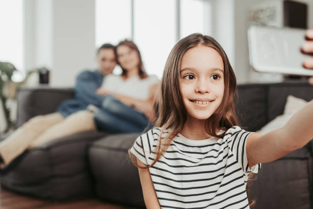 istock Smiling girl making selfie with parents at home 1137013626