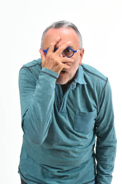 istock man peeking with hand on face on white background 1137015136