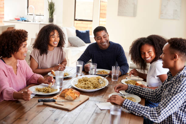 pareja negra de mediana edad sentada en la mesa comiendo con sus hijos, de cerca - sibling brother family with three children sister fotografías e imágenes de stock