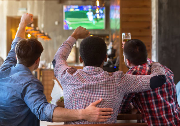 male friends watching football match on tv in bar - fan sport football male imagens e fotografias de stock