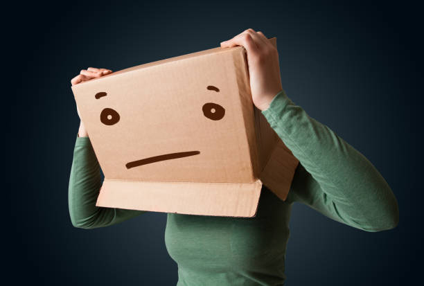 istock Young girl gesturing with a cardboard box on her head with straight face 1137015819
