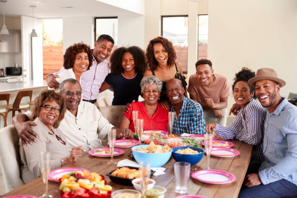 istock Senior black couples sitting at dinner table celebrating at home with family,selective focus 1137018482