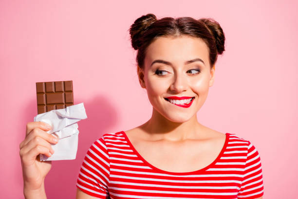 nahauf-porträt von netten niedlichen charmanten, charmanten, glamourösen fröhlichen mädchen, die gestreifte t-shirts trägt, die in den händen suchen lieblings-dessert-leben lifestyle werbe isoliert auf rosa hintergrund - versuchung stock-fotos und bilder