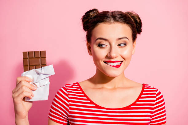 Close-up portrait of nice cute charming attractive winsome glamorous cheerful girl wearing striped t-shirt holding in hands looking favorite dessert life lifestyle advert isolated on pink background Close-up portrait of nice cute charming attractive winsome glamorous cheerful girl wearing striped t-shirt holding in hands looking favorite dessert life lifestyle advert isolated on pink background. chocolate stock pictures, royalty-free photos & images