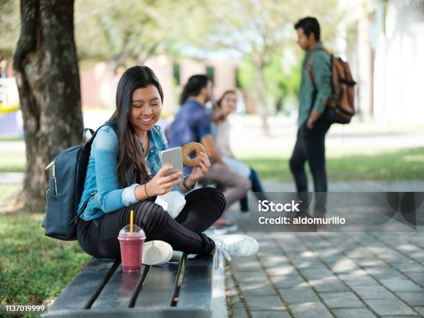 College Student Snacking And Texting Stock Photo - Download Image Now - Student, University Student, Mobile Phone