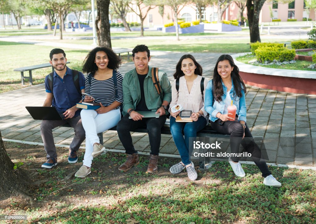 Confident group of university students A group of multi-ethnic university students sitting together outside looking confident towards camera. Honduras Stock Photo