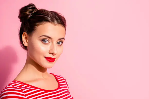 Close up side profile view photo beautiful amazing she her lady pretty buns look self-confidently on camera bright pomade lipstick wear casual striped red white t-shirt isolated pink background.
