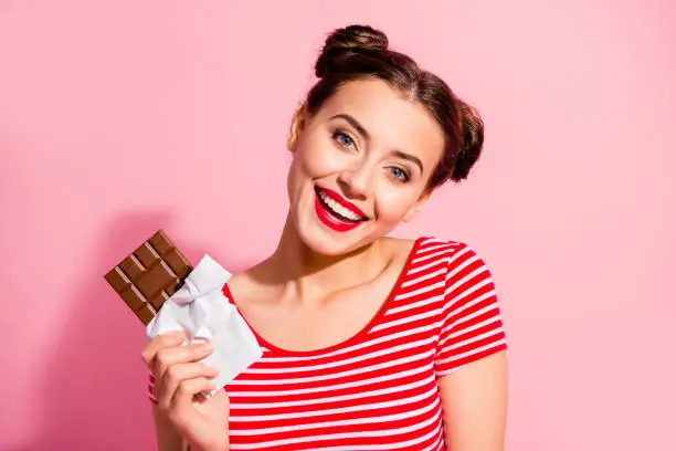 Photo of Close-up portrait of her she nice cute charming attractive winsome glamorous cheerful cheery girl wearing striped t-shirt holding in hands favorite dessert isolated over pink pastel background