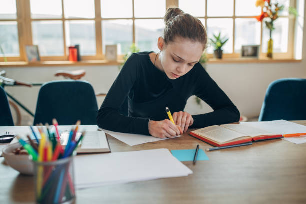 istock Girl student doing homework at home 1137021753