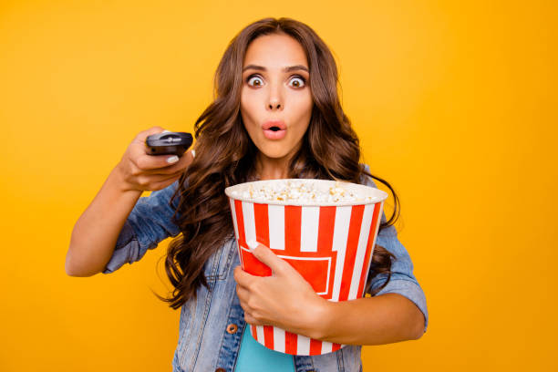close up photo beautiful her she lady hold big large popcorn box stupor staring oh no expression change channel wear blue teal green short dress jeans denim jacket clothes isolated yellow background - remote television movie box imagens e fotografias de stock