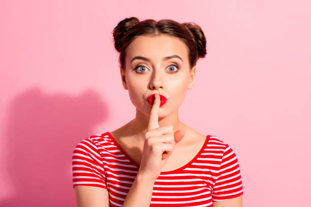 close up photo beautiful she her lady pretty buns bright pomade lipstick arm hand finger lips asking not talk tell speak fellow friend wear casual striped red white t-shirt isolated pink background - finger on lips whispering secrecy silence imagens e fotografias de stock