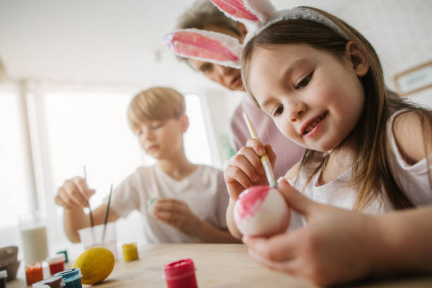 istock Low angle of little girl painting Easter egg in kitchen 1137028523