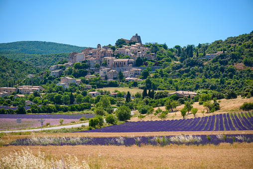 Ciudad de saint-saturnin-les-apt en la colina con campos de lavanda en el valle photo