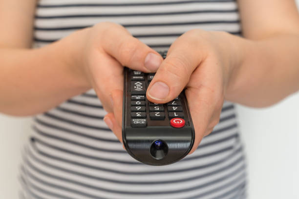istock Remote control in female hands pointing to TV 1137029818