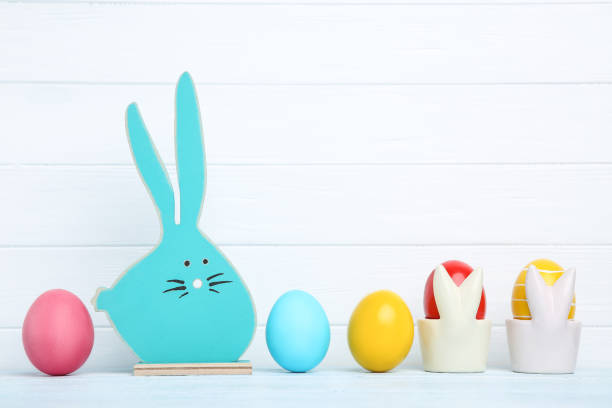 istock Colorful easter eggs with blue wooden rabbit on white background 1137030303