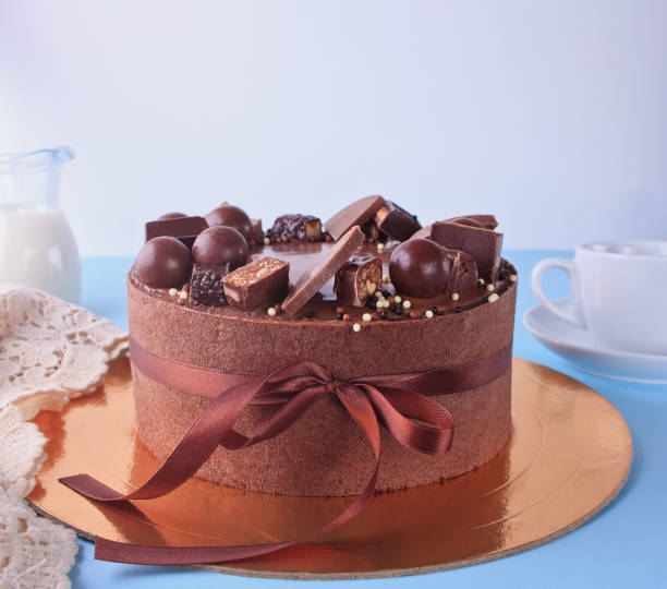 istock Chocolate cake with candy and ribbon on a blue table 1137030324