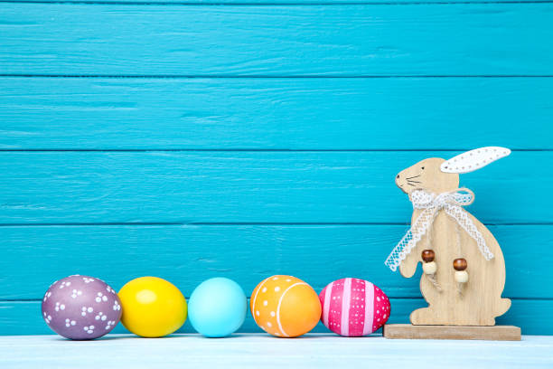 istock Colorful easter eggs with wooden rabbit on blue background 1137030552