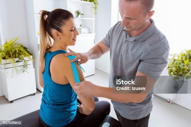 Kinesio Taping On Womans Arm Stock Photo - Download Image Now - Elastic Therapeutic Tape, Adhesive Tape, Adult