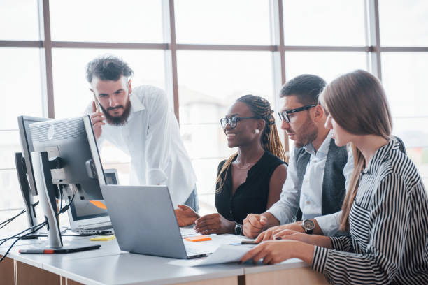 istock Young employees sitting in the office at the table and using a laptop, a team work brainstorming meeting concept. 1137031941