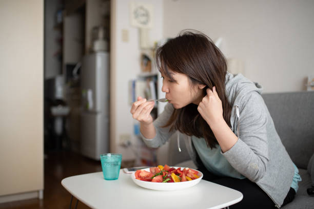 istock Woman eating salad in room 1137032287