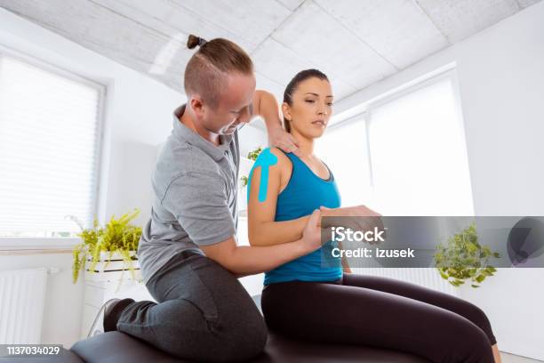 Physiotherapist Massaging Young Woman Stock Photo - Download Image Now - Medical Exam, Recovery, Shoulder