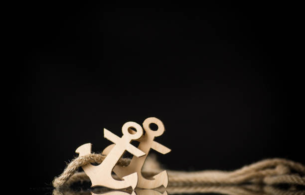 two wooden decorative anchors on a black background
