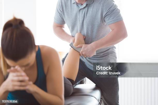 Physiotherapist Massaging Womans Leg Using Tools Stock Photo - Download Image Now - Achilles Tendon, Massaging, Metal