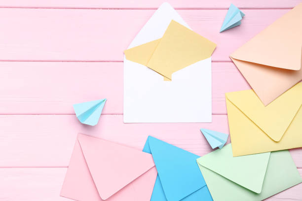 istock Colorful envelopes with paper planes on pink wooden table 1137035810