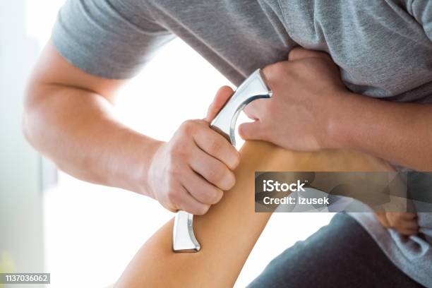 Physiotherapist Massaging Womans Leg Using Tools Stock Photo - Download Image Now - Achilles Tendon, Adult, Adults Only