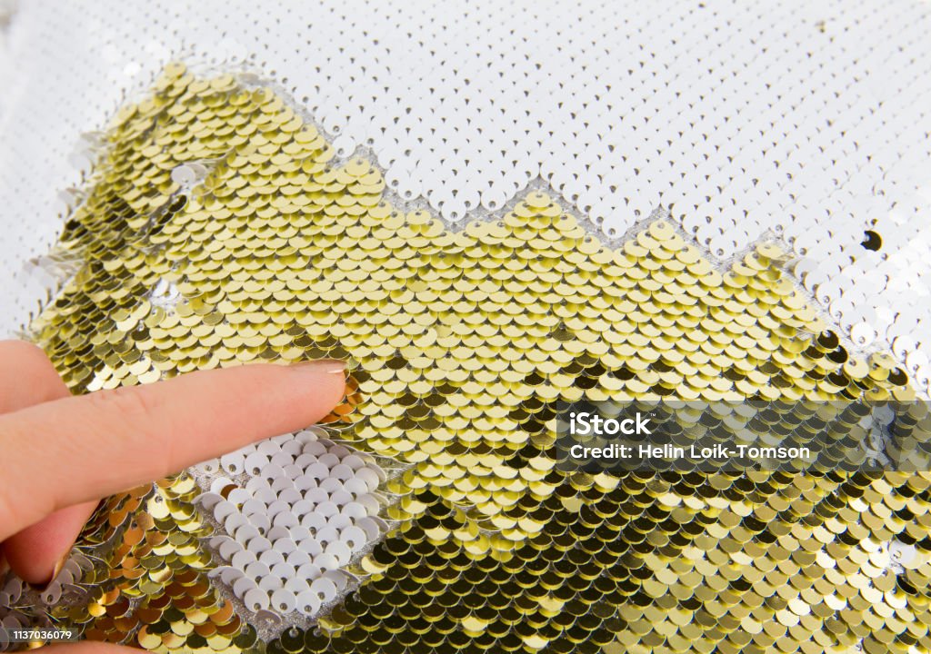 Nahaufnahme der Frau Fingerspiel mit Gold und weißen Schimmer Pailletten reversiblen Stoff. Kunsthandwerk Material-Ideenkonzept und großer Stress erleben die geschäftige Urlaubszeit. - Lizenzfrei Paillette Stock-Foto