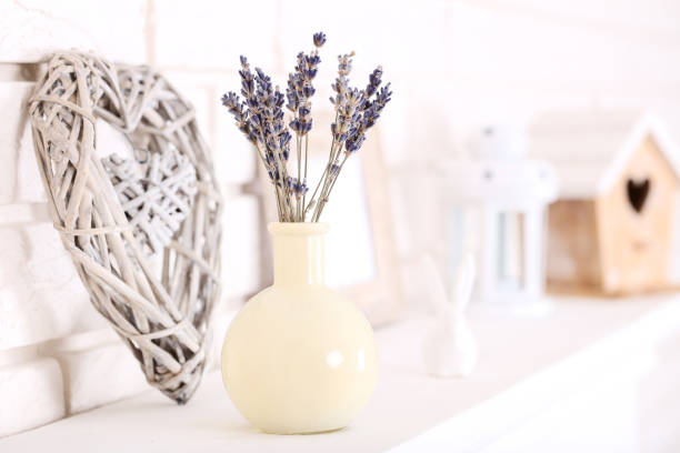 istock Lavender flowers in vase with decorative heart on white fireplace 1137038485