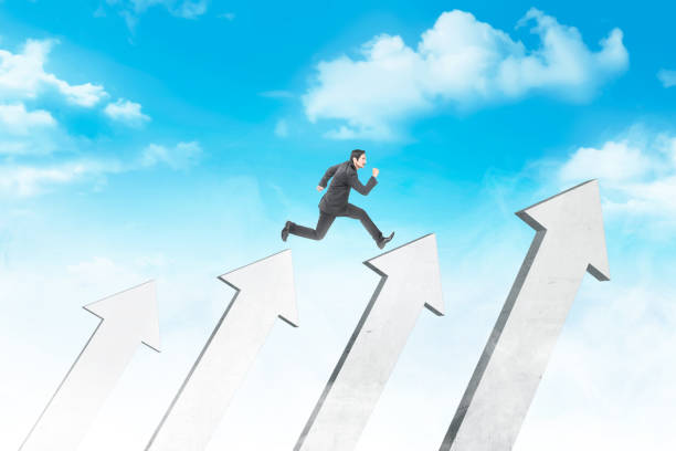 istock Attractive asian businessman jumping above white arrows 1137038501