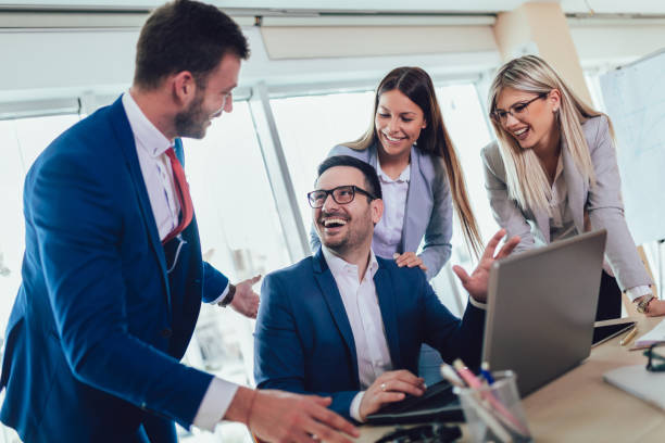istock Group of young business people working and using laptop while sitting at the office desk together. 1137039984