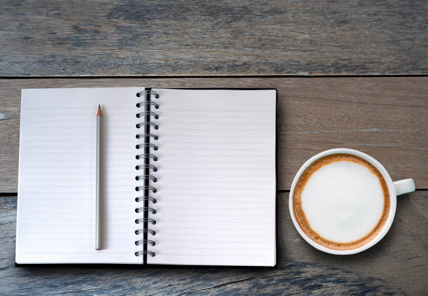 istock notebook and cup of coffee over wooden desk. 1137040061