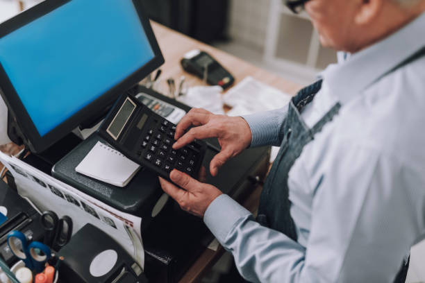 istock Male entrepreneur using calculator and working at cash desk 1137040786