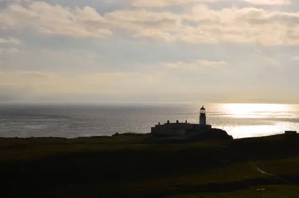 Beautiful silhouetted lighthouse at Neist Point at sunset.