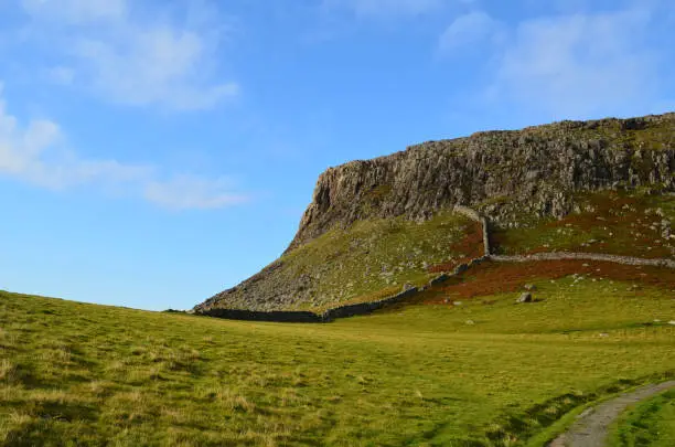 Neist Point's landscape with pastures, rolling hills and sea cliffs in Scotland.