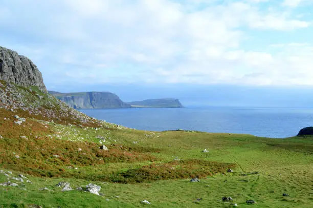 Rugged landscape and sea cliffs along the rocky shore of Neist Point in Scotland.