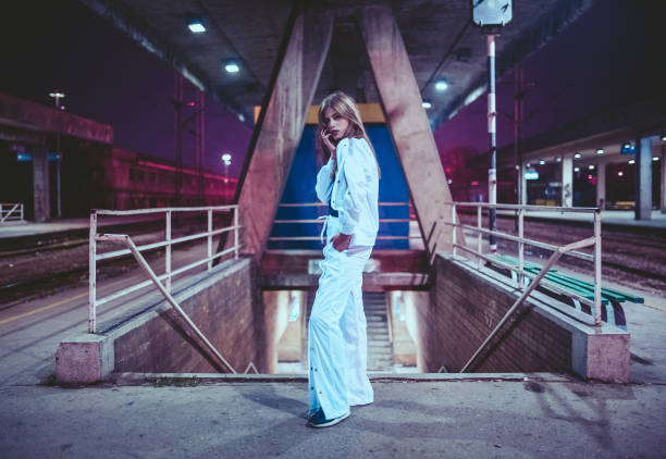 Young fashionable woman posing on a railway station platform