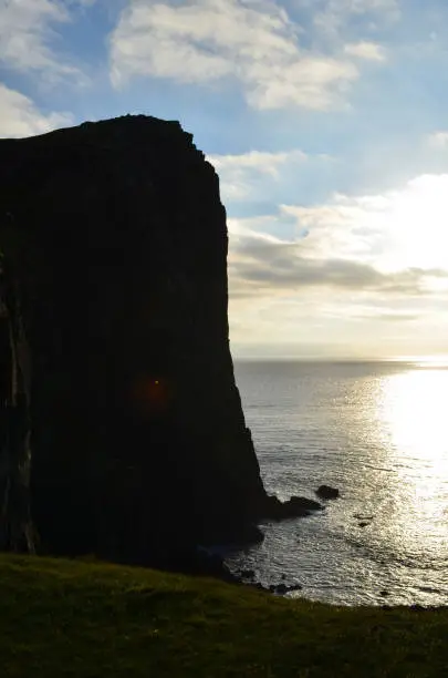 Silhouetted towering sea cliff on Skye in Scotland.