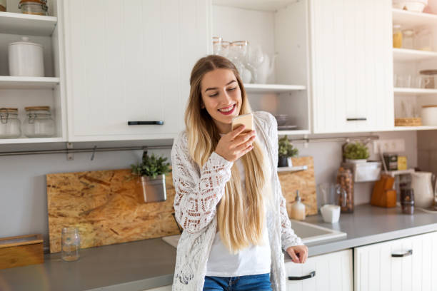 istock Young woman using her smartphone at home 1137044449