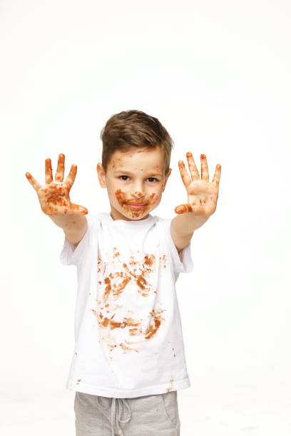 istock little boy with face and hands in chocolate 1137045364
