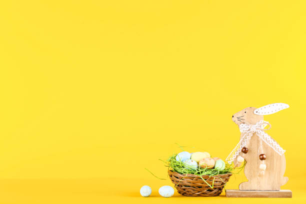 istock Easter eggs with wooden rabbits on yellow background 1137046033
