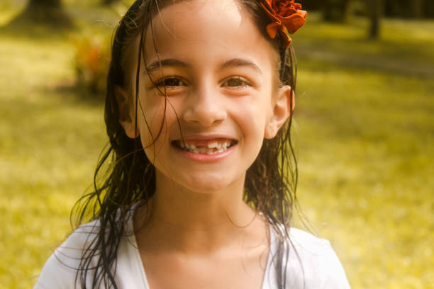 Toothless young girl smiling looking at the camera