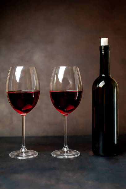 istock Red wine glasses and a bottle with wine on a stone background. View from above 1137047406