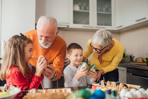 istock Couple decorating eggs with grandchildren 1137048743
