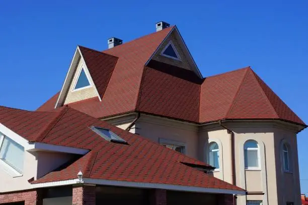 red tiles on the roof of the attic with a window against the blue sky