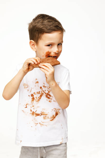 istock little messy boy is eating chocolate studio shot 1137048803