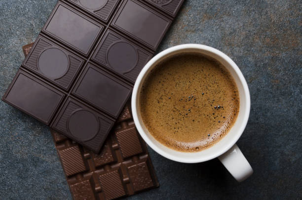 Several chocolate bars and hot tasty coffee with brown great foam